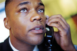 African American man on the phone with a worried look on his face