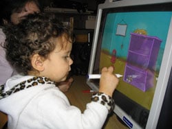young girl using touch screen to access a computer game