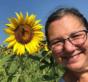 Robbi Weil next to sunflowers