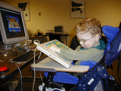 young boy in a wheelchair using an Intellikeys keyboard to access a computer program