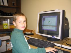 teen reading a book on the computer