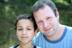 man with arm around young boy