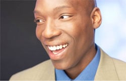 African American businessman smiling, looking off to the side.