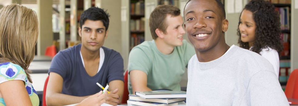Group of students studying with one student smiling